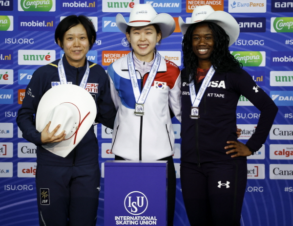 김민선(가운데)이 16일(현지시간) 캐나다 캘거리의 올림픽 오벌에서 열린 2022-23 국제빙상경기연맹(ISU) 스피드스케이팅 월드컵 4차 대회 여자 500ｍ 디비전A 정상에 올라 금메달을 목에 걸고 기념 촬영을 하고 있다. [캘거리=AP/뉴시스]